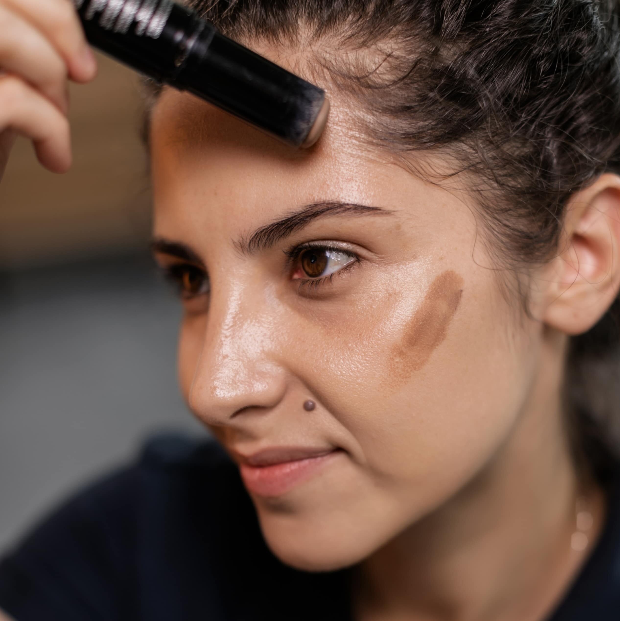 girl applying eyeliner on mirror